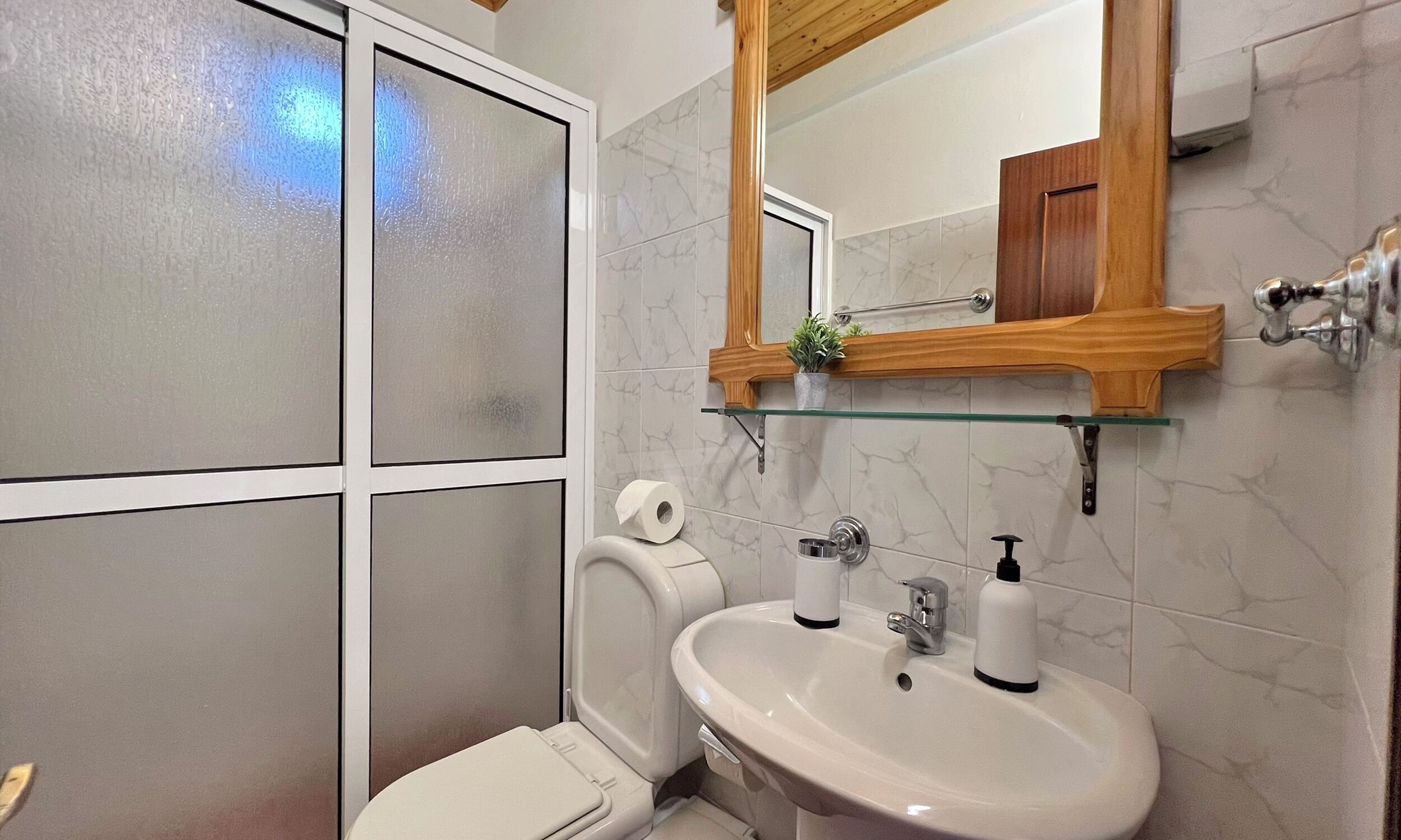 Une salle de bain avec des toilettes, un lavabo et un miroir.