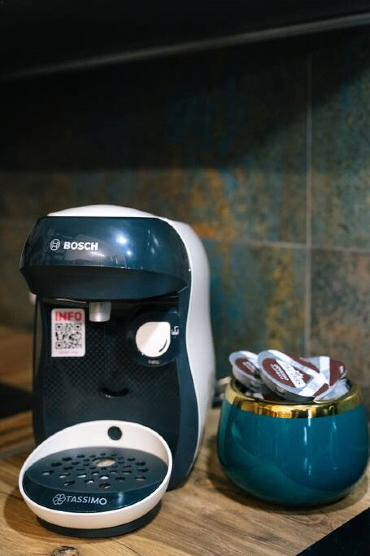 A Bosch coffee maker with a Tassimo pod holder on a wooden surface.