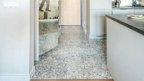 Eine moderne Küche mit Granitarbeitsplatte, integriertem Backofen und Spüle aus Edelstahl.