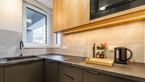 A modern kitchen with a built-in microwave, a sink, and a coffee maker on the counter.