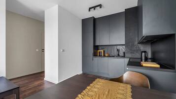 Een moderne keuken met donkere kastjes, een houten eettafel en een keukeneiland.