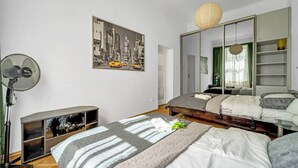 Ein modernes Schlafzimmer mit Bett, Nachttisch und einem großen Spiegel.