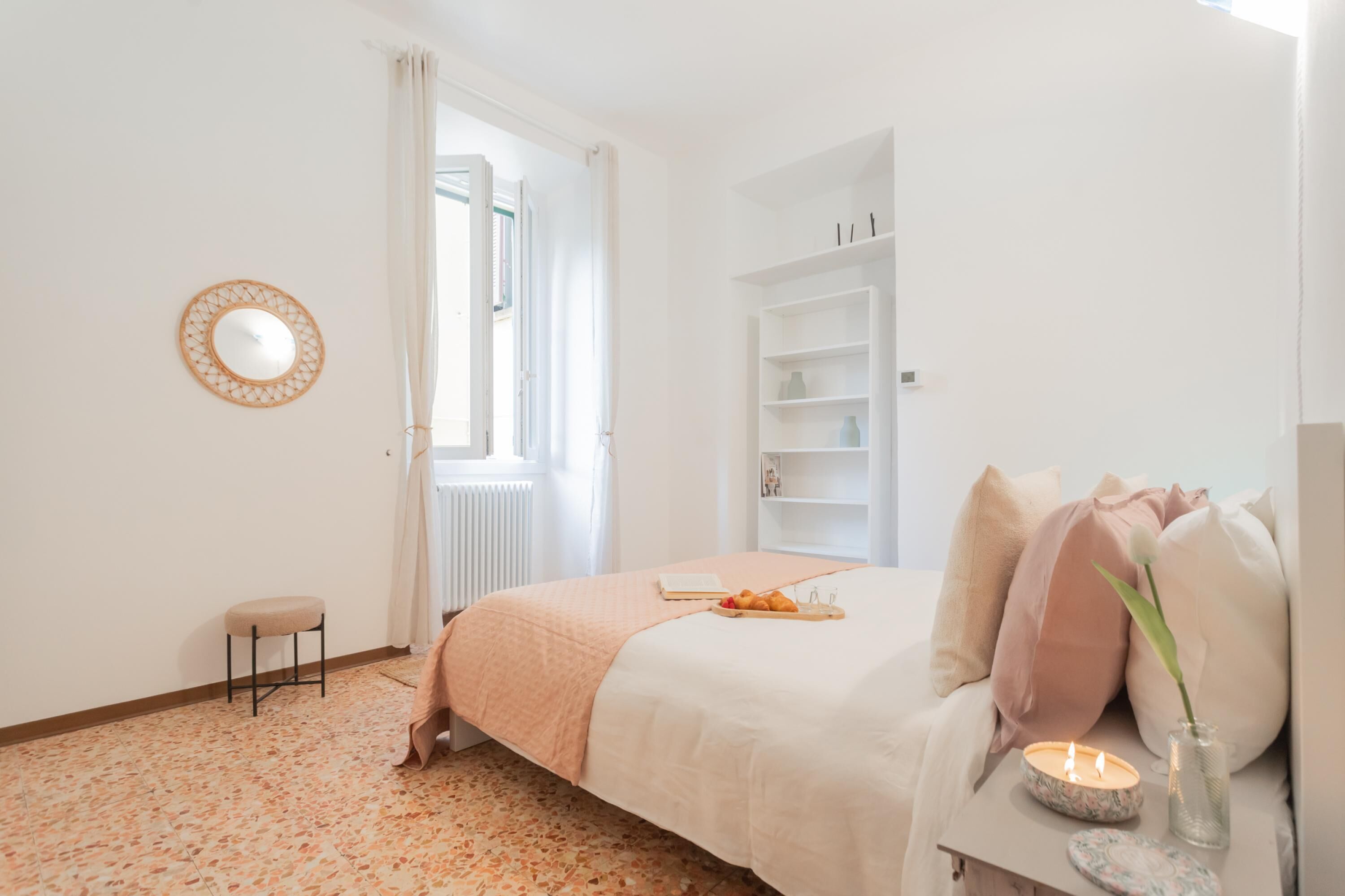 Een slaapkamer met een bed, nachtkastje en een raam.