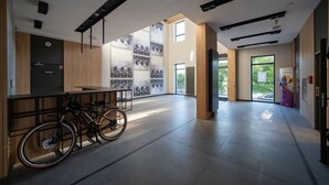 Un hall d’entrée spacieux, doté d’un porte-vélos, de grandes fenêtres et d’un design moderne.