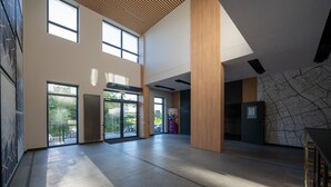 Un hall d  ’entrée spacieux, doté de hauts plafonds, de grandes fenêtres et d’un design moderne.