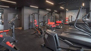 Une salle de sport moderne équipée de divers appareils d’exercice, notamment des tapis de course, des vélos d’appartement et des appareils de musculation.