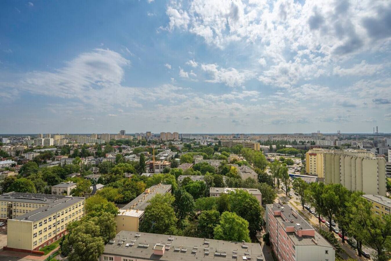 A cityscape with a mix of residential and commercial buildings, including a large industrial facility.