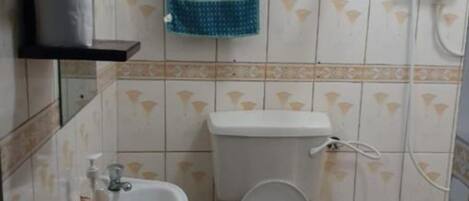 A small bathroom with a toilet, sink, and a green trash bin.