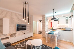 A modern apartment with a living area, kitchen, and dining space.