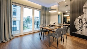 Un comedor moderno con una mesa de madera, sillas grises y un ventanal con cortinas.
