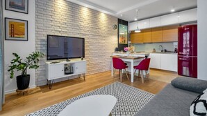 A modern living room with a TV, dining area, and kitchen. - Warsaw Wola - Parking & Balcony - by Rentujemy (Warszawa)