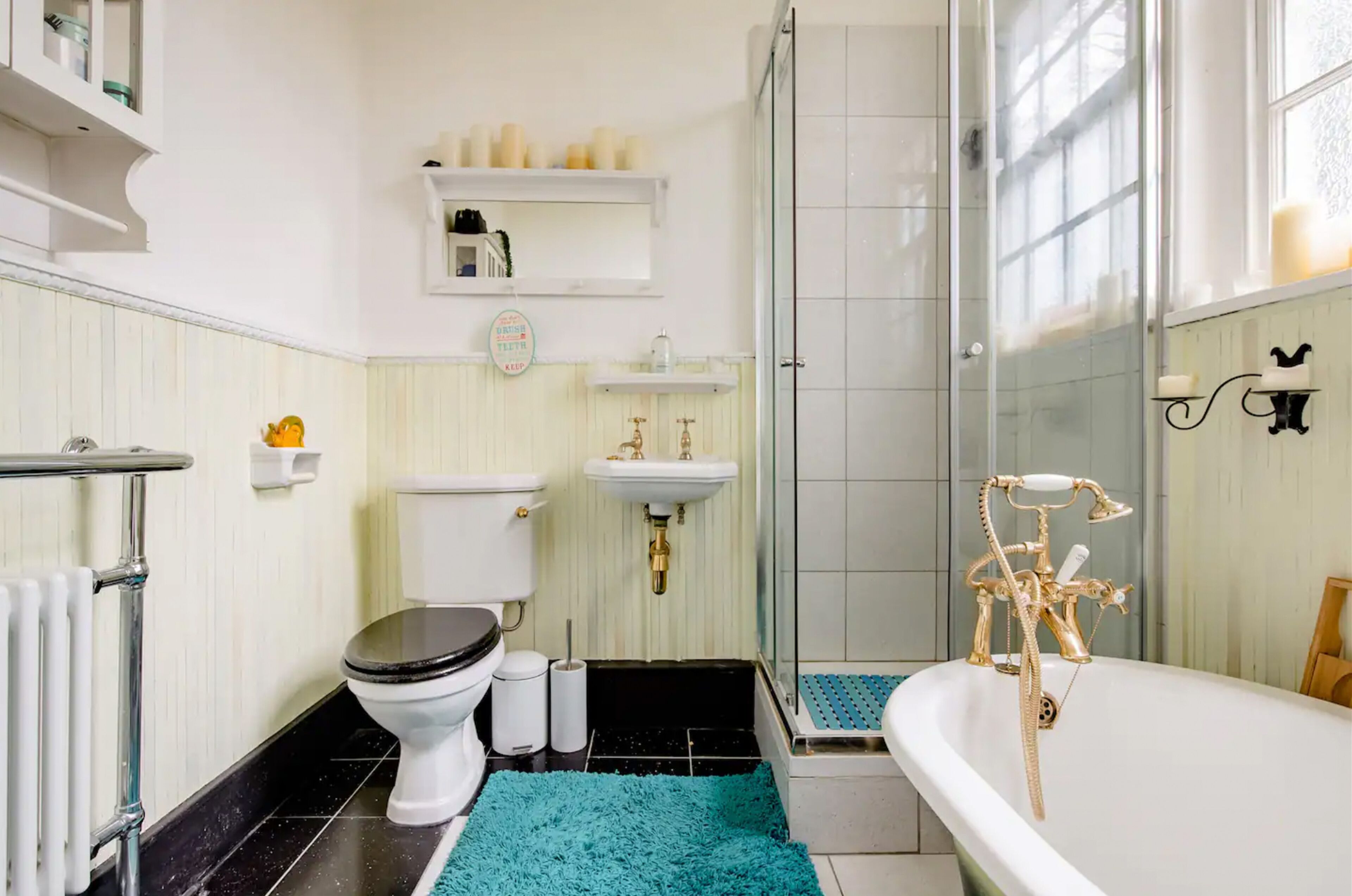 A bathroom with a toilet, sink, bathtub, and shower.