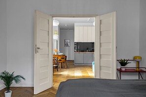 A modern room with a bed, a dining area, and a kitchen.
