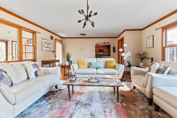 Relax in this inviting living space with a sofa set, coffee table, and kitchen area.