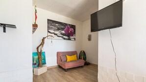 A room with a sofa, a painting, and a mounted TV. - 3835 Summer House by Barbarhouse (Porto Cesareo)
