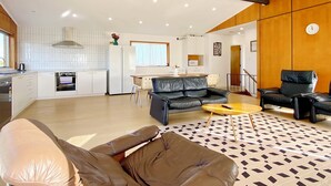 A modern living space with a kitchen, dining area, and seating area. - Waterfront villa near IKEA and Sylvia Park (Auckland)