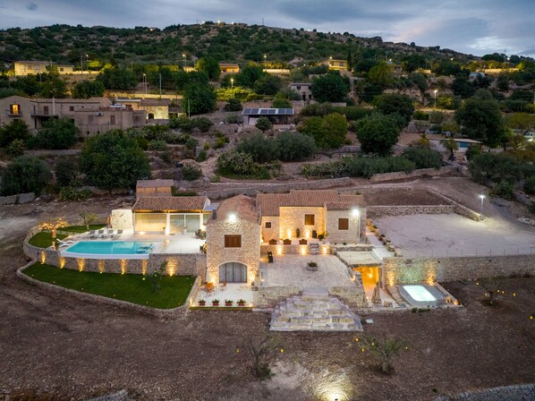 A villa with a swimming pool, stone architecture, and a hillside view. - Villa Domus Sicilia - Charming Living (Modica)