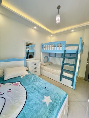 A bedroom with bunk beds, a dresser, a mirror, and a ceiling light. - Sharm Hills Aqua park Resort (Sharm El Sheikh)