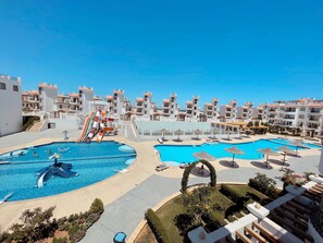 A resort with multiple swimming pools, a water slide, and a view of the sea. - Sharm Hills Aqua park Resort (Sharm El Sheikh)