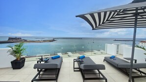 A terrace with lounge chairs and a view of the sea. - Blue Marina Suites Boutique Apartments (Arrecife)