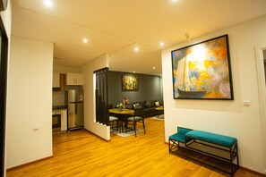 A modern living space with a dining area, kitchen, and a large abstract painting on the wall. - ABM House (Tangier)