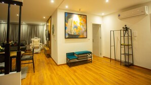 A spacious living room with a wooden floor, a large painting, a bench, a chair, and a small table. - ABM House (Tangier)