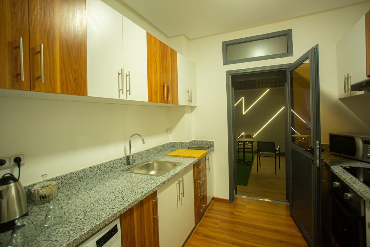 A modern kitchen with granite countertops, wooden cabinets, and stainless steel appliances.