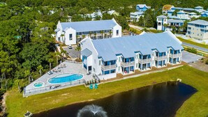 Um hotel grande com vários edifícios, piscina e um lago.