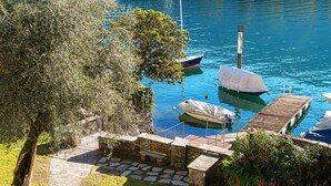 A stone pathway leading to a dock with boats. - Olea (Tremezzina)