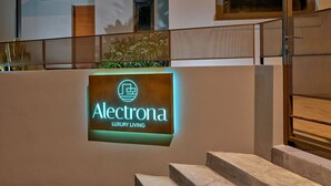 A sign for Electrona Luxury Living with a modern design and a staircase leading to an upper level. - Olivea Slow Living Apartment with Pool in Chania | Alectrona Living Crete (Πλατανιάς)
