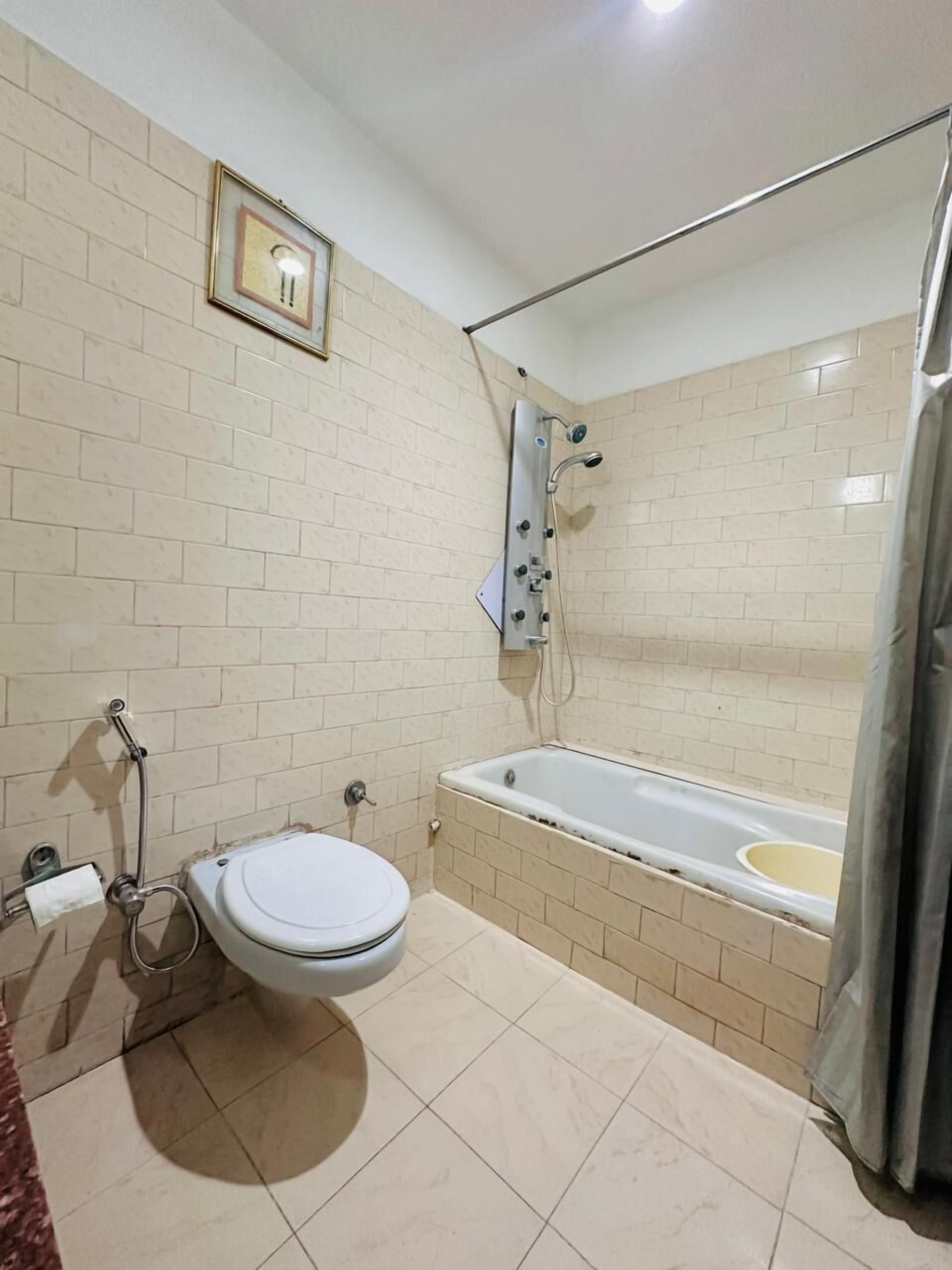 A bathroom with a toilet, a bathtub, and a shower.