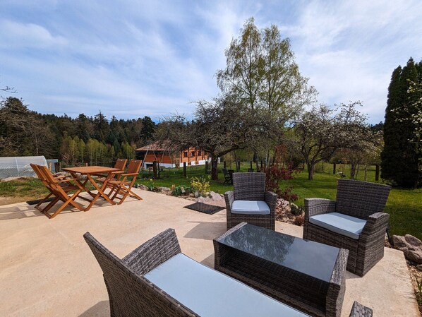 Relax in the serene outdoor patio area with a variety of seating options, including a table, chairs, and a sofa.