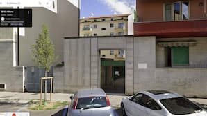 A street view with a building that has a green door and a sign with "IS ITAMO" written on the wall. There are two cars parked in front of the building. - VENICE NIGHT 25 FAMILY ROOM D (Mestre)