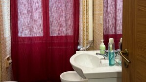A bathroom with a red shower curtain, a white sink, and a toilet. - VENICE NIGHT 25 FAMILY ROOM D (Mestre)