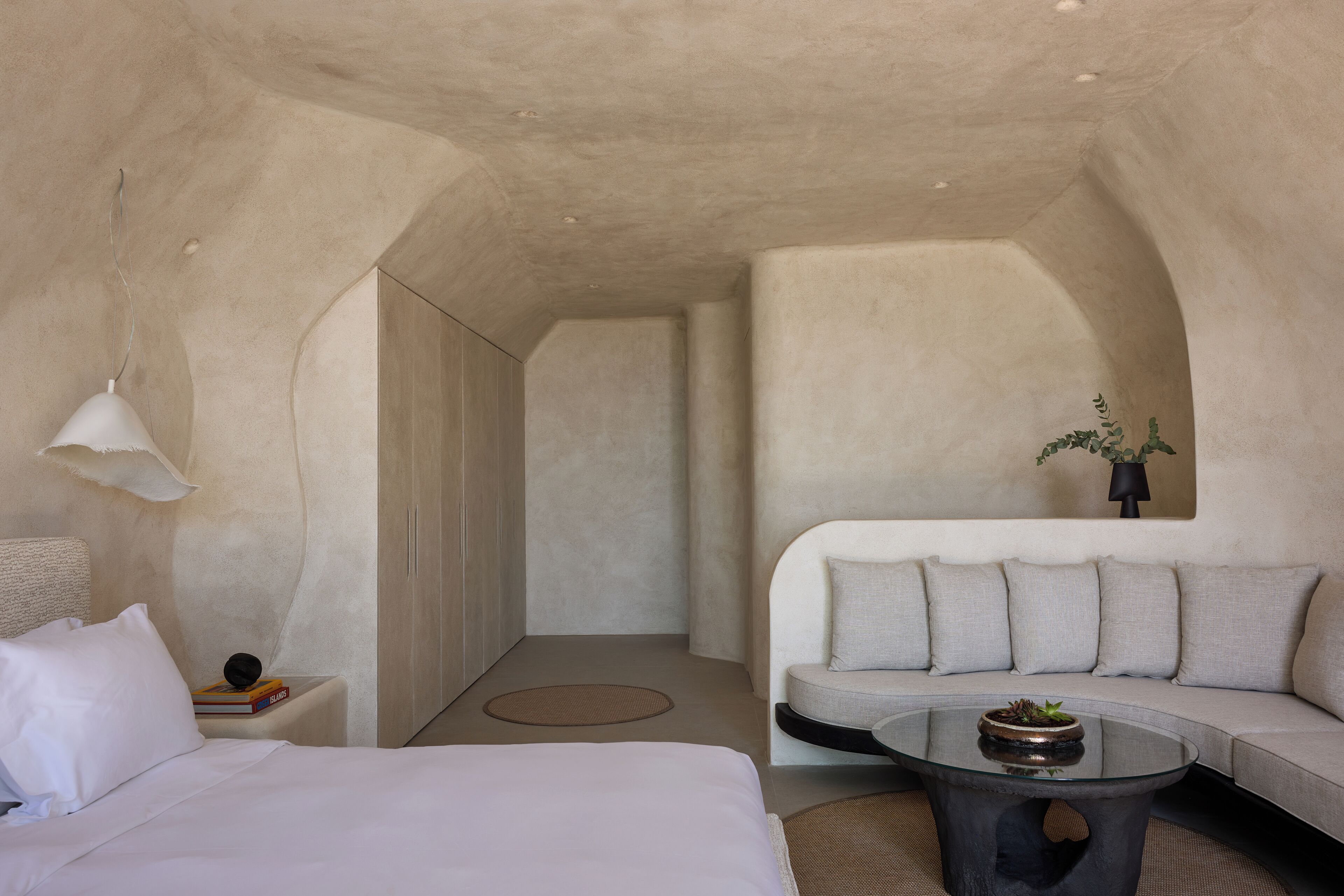 Een moderne, minimalistisch ingerichte kamer met een bed, een bank en een salontafel.