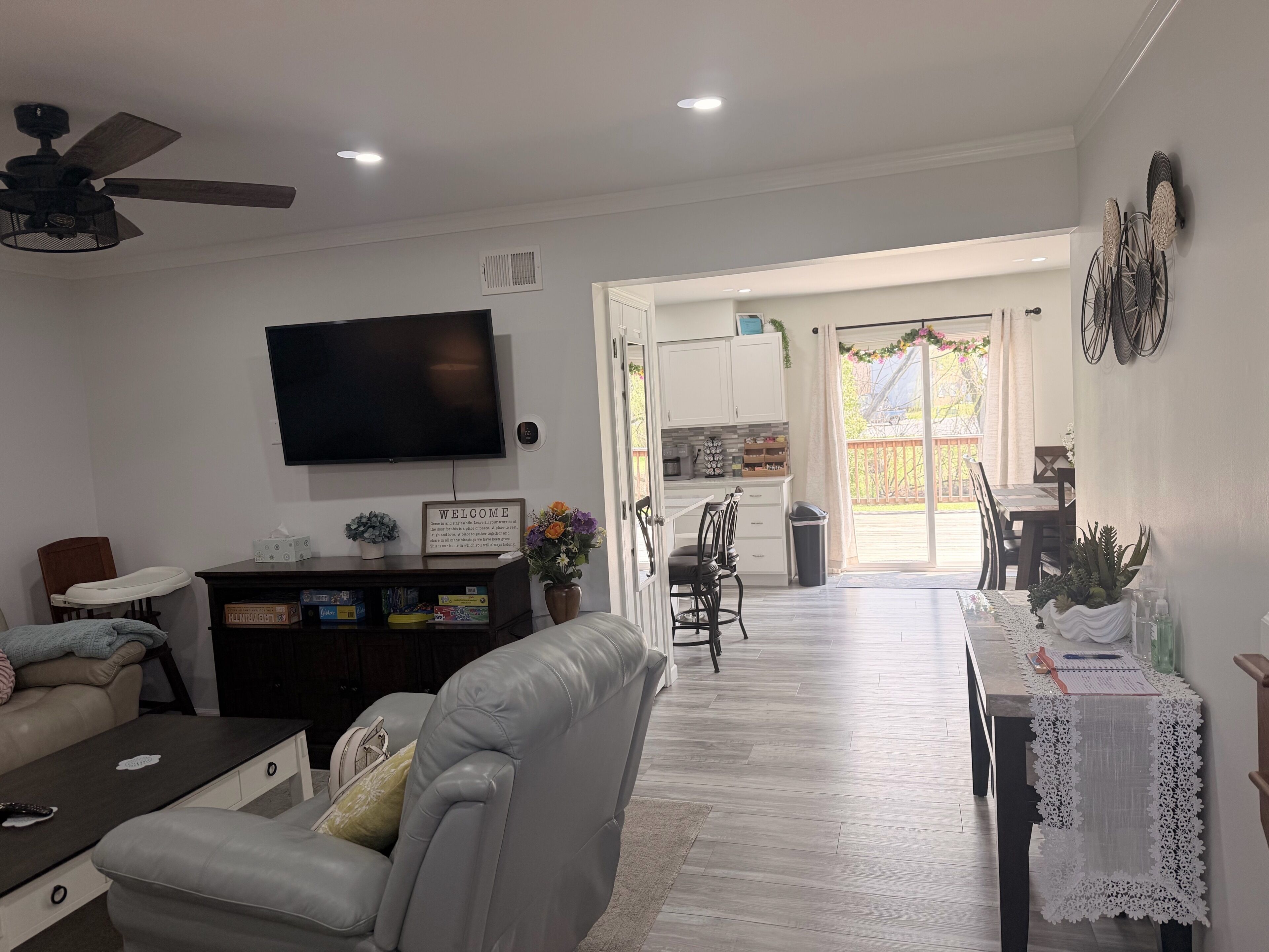 Un salon comprenant un canapé, un fauteuil inclinable, un téléviseur et un ventilateur de plafond.