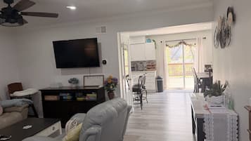 Un salon comprenant un canapé, un fauteuil inclinable, un téléviseur et un ventilateur de plafond.