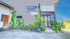 Ein Gebäude mit Schildern für 'D'HARJO GUEST HOUSE' und 'NadalEmHang'.