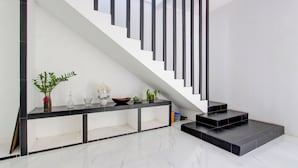 Eine moderne Treppe mit schwarzen Geländern und einer schwarzen Plattform am unteren Ende.
