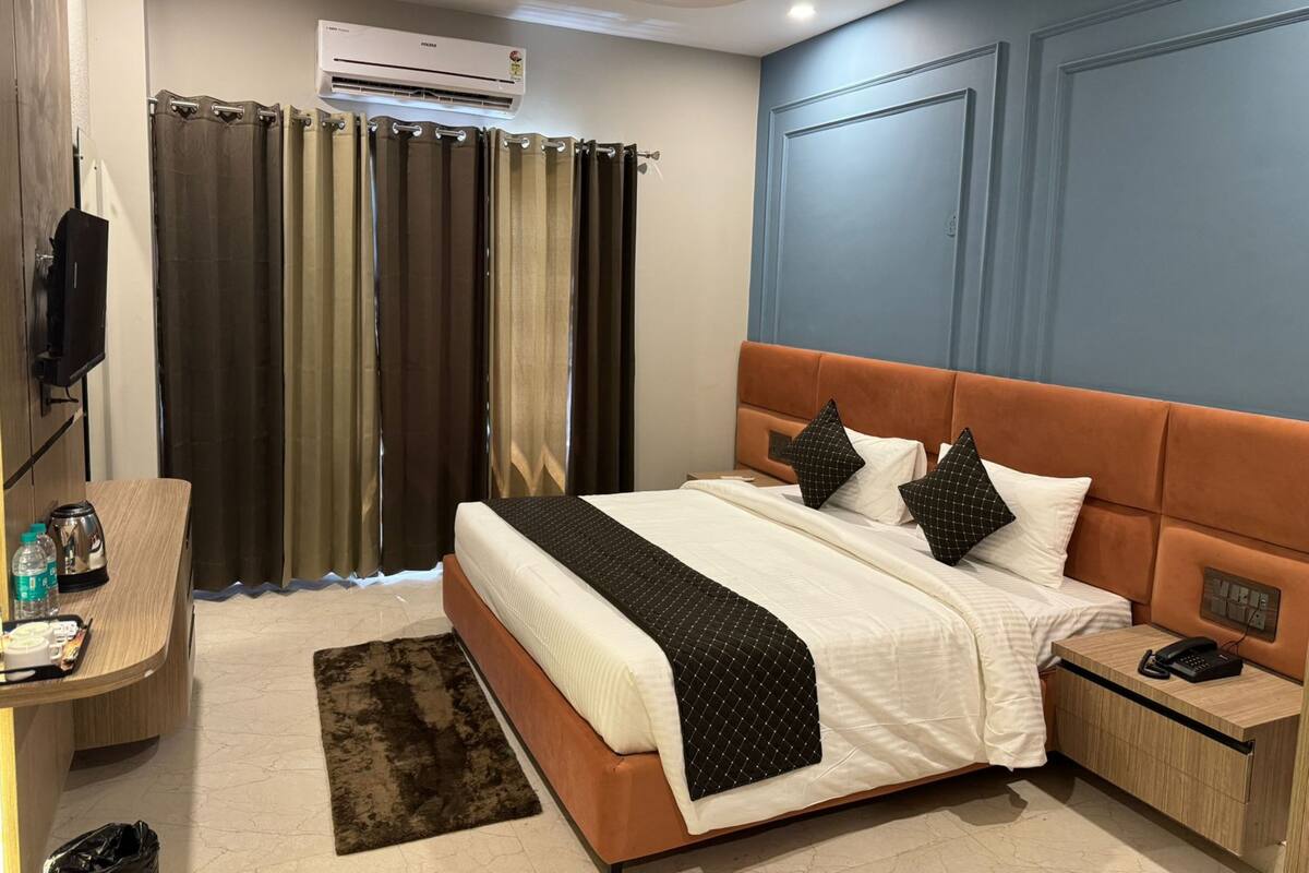 Una habitación de hotel moderna con una cama, una mesita de noche y un escritorio con una silla.