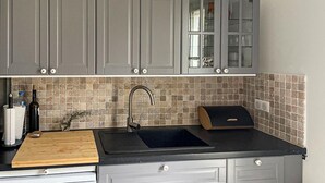 A kitchen with grey cabinets, a black sink, and a tiled backsplash. - Awesome home in Saint-Rémy-de-Provence (Saint-Rémy-de-Provence)