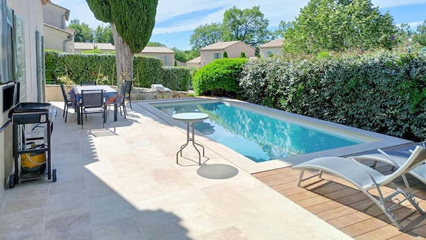 A swimming pool with a wooden deck, a table, and chairs. - Awesome home in Saint-Rémy-de-Provence (Saint-Rémy-de-Provence)