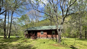 A rustic cabin with a porch, surrounded by trees and grass. - Peaceful Cabin Steps Away From The Creek, Convenient Access To ATV Trails! (Mena)