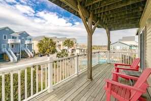 A wooden deck with a railing, overlooking a beach area with houses and a pool. - Followin' The Son Too - 3 BR in Calinda Cay; Comm. Pool & Ocean Views (North Topsail Beach)