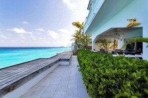 A pathway leading to a poolside area with a view of the ocean. - Belmar Oceanfront Apartment 1, sea views (Kralendijk)