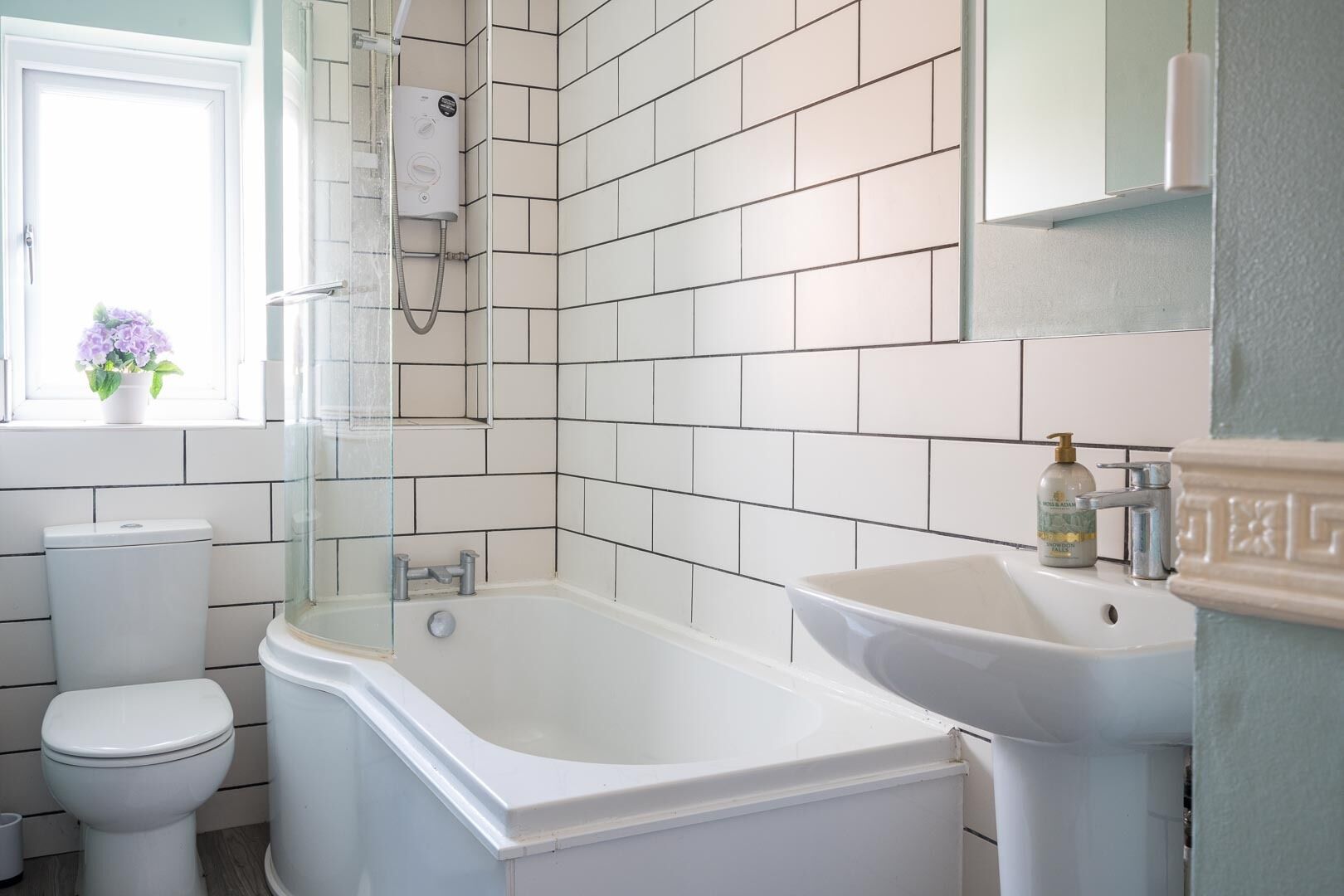 A bathroom with a white toilet, a bathtub, and a sink.