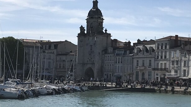 Un bâtiment historique doté d’une tour imposante et offrant une vue sur le front de mer.