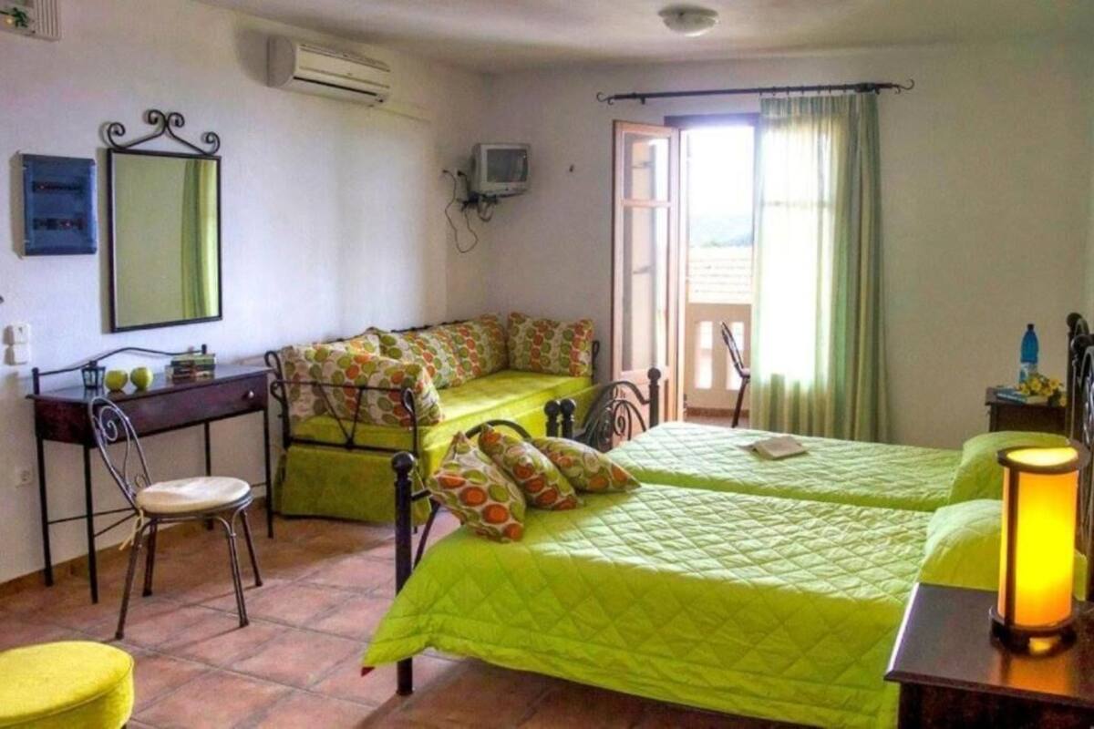 A room with two beds, a desk, a chair, a mirror, and a television.