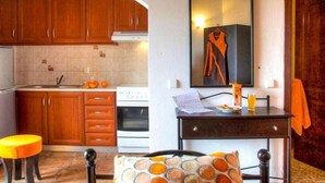 Une cuisine de taille réduite, dotée de meubles en bois, d’une cuisinière et d’un coin repas avec une table et des chaises.