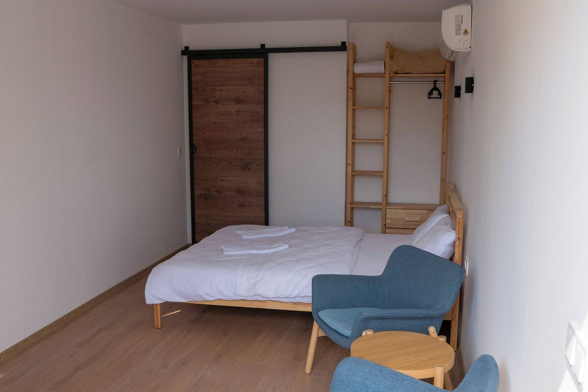 Ein kleines Zimmer mit Etagenbett, Schreibtisch und Stuhl.